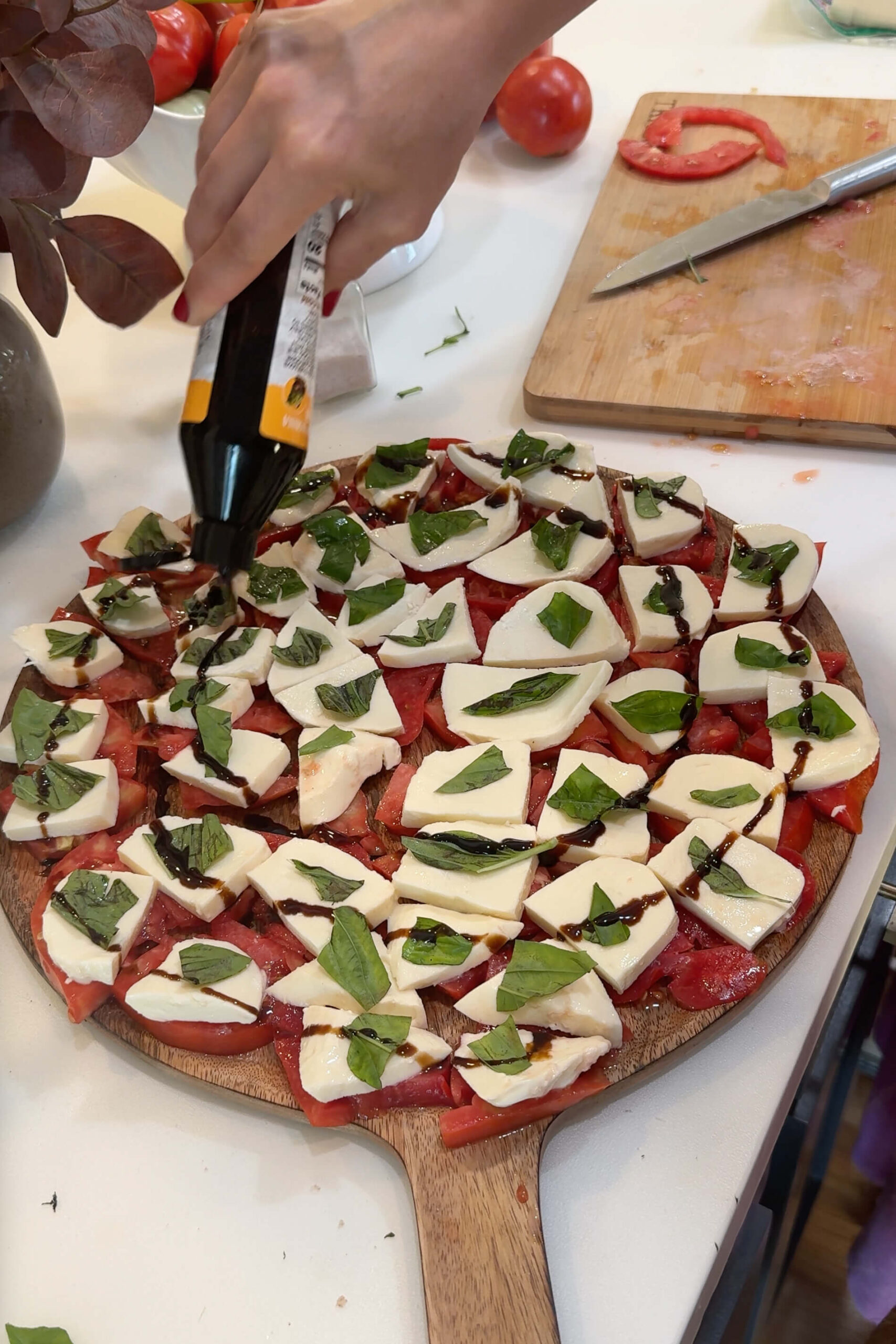 Drizzling Balsamic Glaze on Caprese salad.